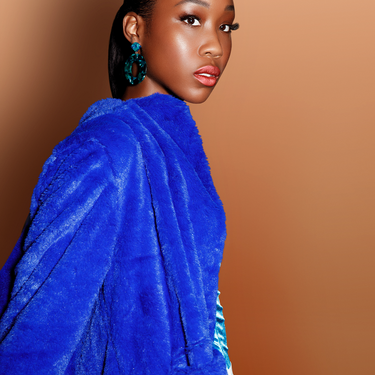 Image of model with deep-toned skin wearing Matte Liquid Lipstick #50 by Beauty For Certain. #50 is a mid-tone shimmer.